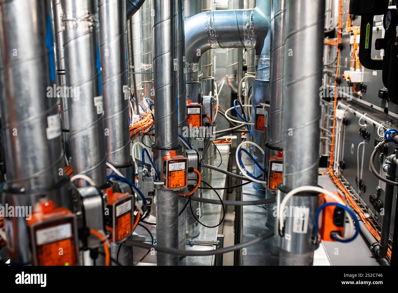 Sistema HVAC industriale con comandi automatici, cablaggio e condotti metallici in un ambiente tecnico Foto Stock