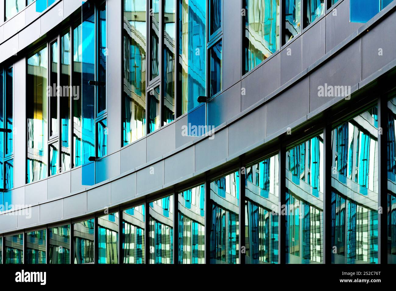 Moderno edificio per uffici in vetro con finestre blu e elegante design architettonico Foto Stock