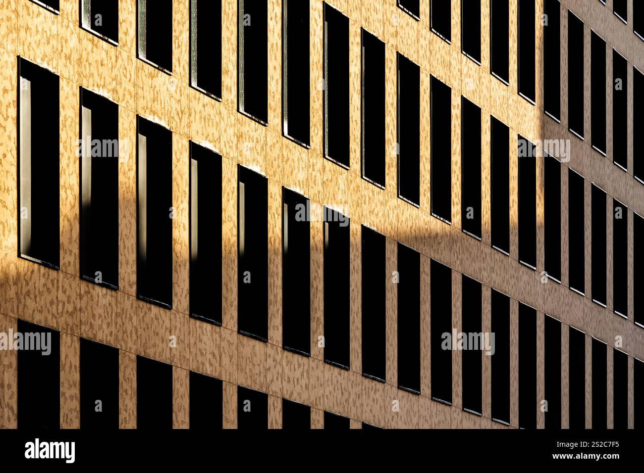 Facciata in mattoni con finestre verticali ripetitive e design architettonico simmetrico Foto Stock