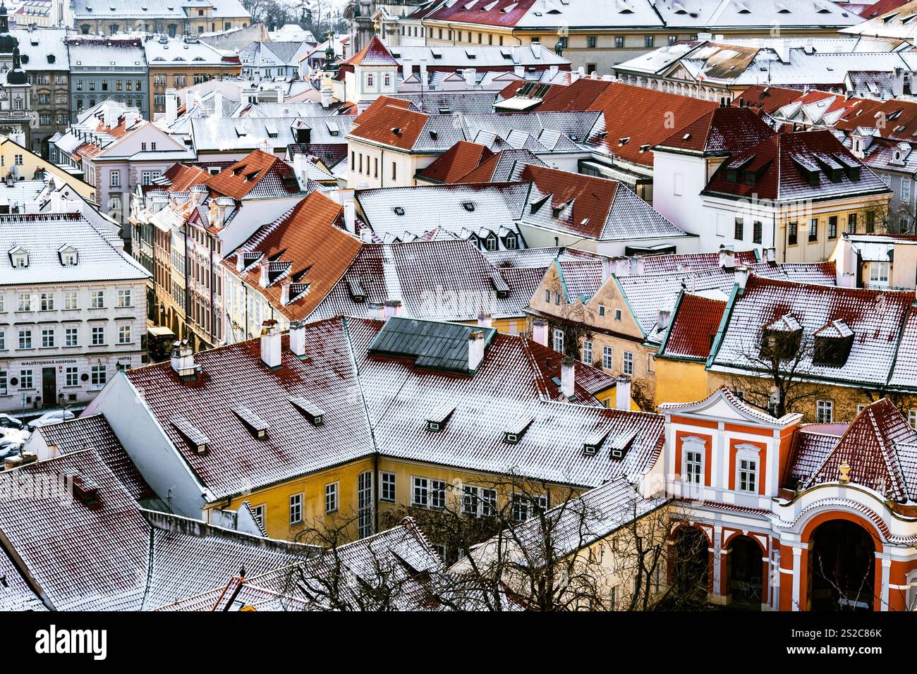 Tetti innevati di Malá strana a Praga con architettura storica e tetti di tegole rosse Foto Stock