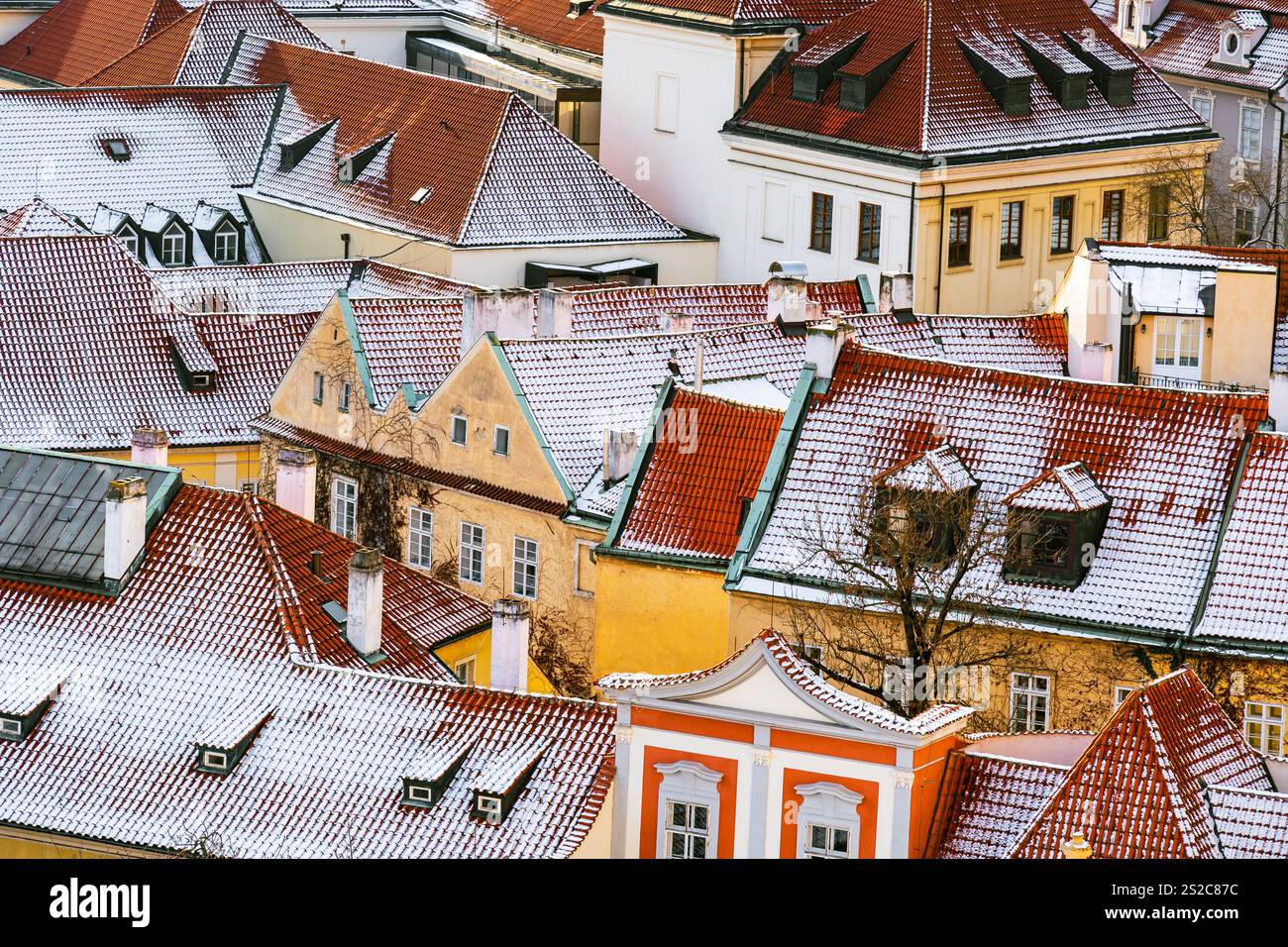 Tetti innevati di Malá strana a Praga con architettura storica e tetti di tegole rosse Foto Stock