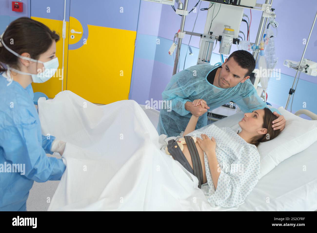 donna incinta durante il parto in sala operatoria Foto Stock