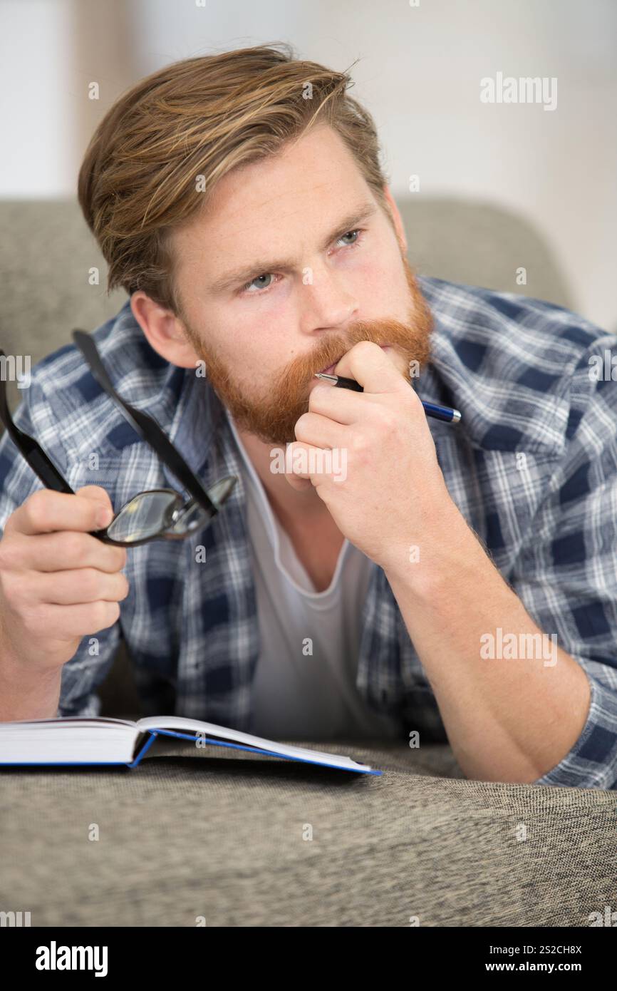 giovane studente uomo d'affari che legge un libro che studia lavorando Foto Stock