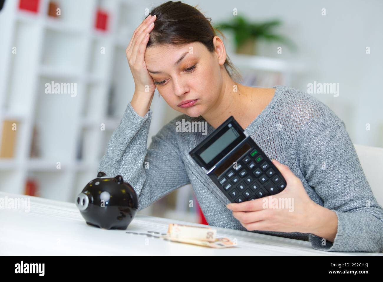 donna triste che legge documenti a casa sua Foto Stock