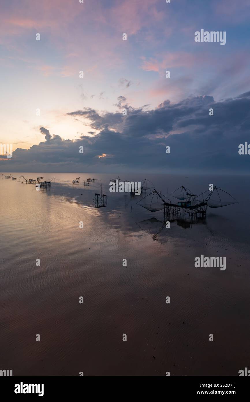 Sagoma delle tradizionali reti da pesca e piattaforme sul fiume Pak Pra all'alba, Phatthalung, Thailandia Foto Stock