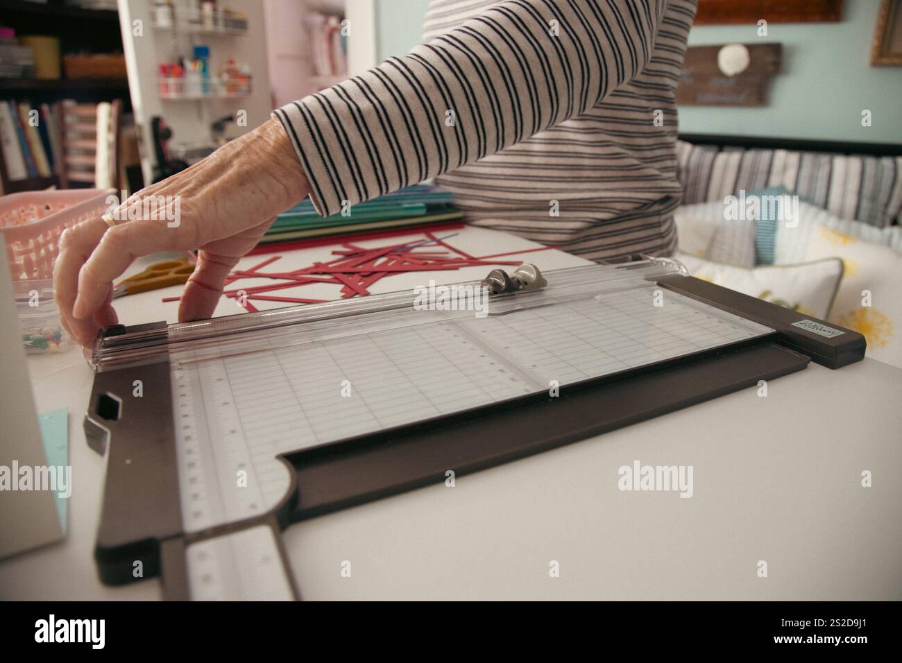 Primo piano di una donna seduta a un tavolo che prepara cartoline di Natale fatte in casa Foto Stock