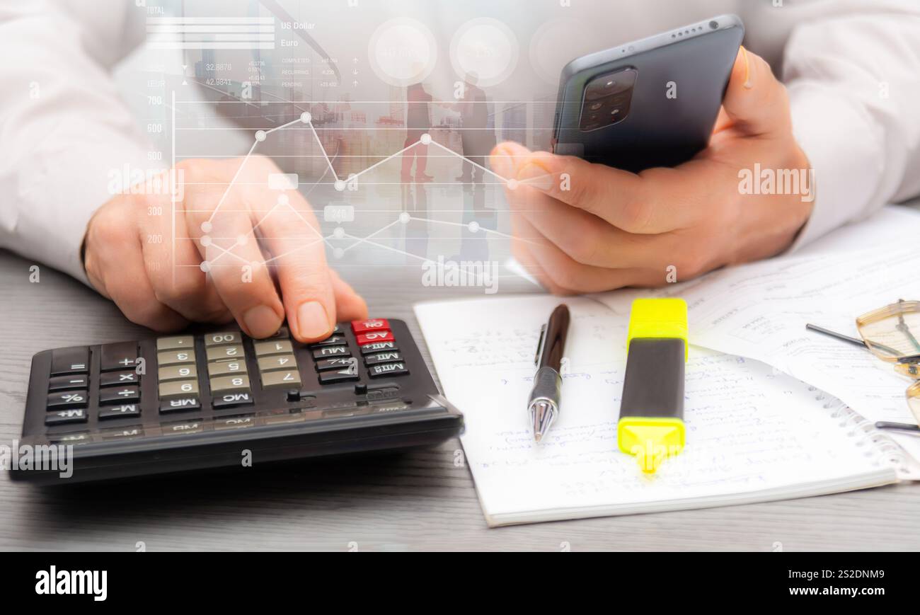 Calcolo delle spese e analisi dei dati finanziari in uno spazio di lavoro professionale con note e cancelleria nelle vicinanze per riferimento. Foto Stock