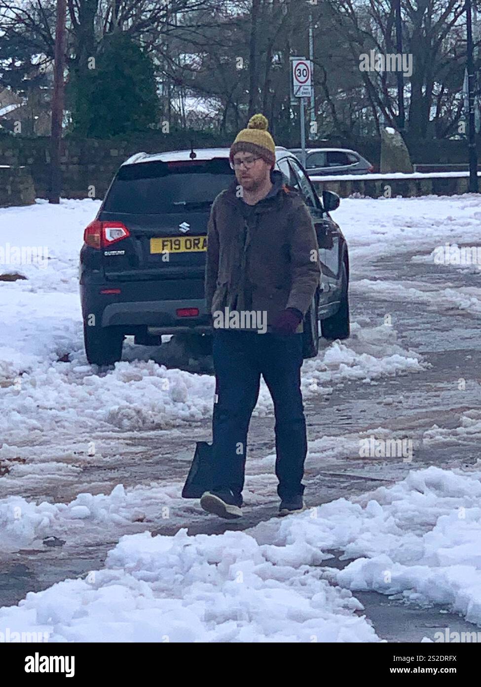 Guiseley North Yorkshire neve ghiaccio tempo di Natale pulizia Clear Drive vialetto Place Town home live neve tempesta di neve Airport Sludge spade man UK - Immagine stock catturata con smartphone