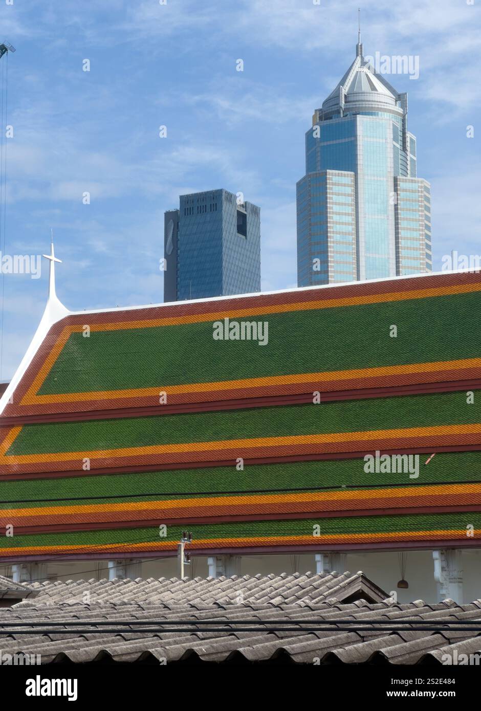 Questa suggestiva immagine cattura la miscela unica di tradizione e modernità nella regione di Sukhumvit a Bangkok. In primo piano, il verde vivace e l'yello Foto Stock