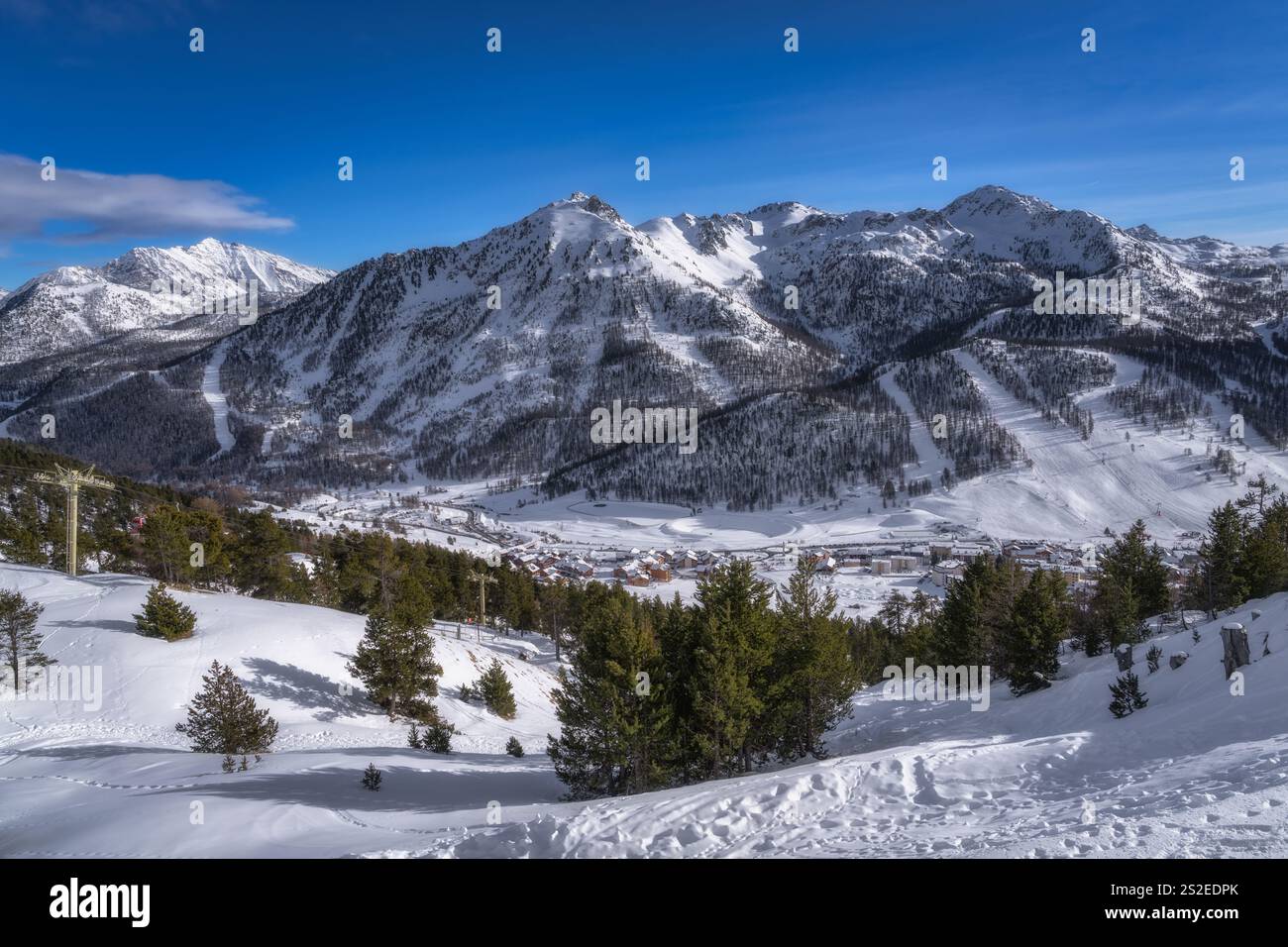 Goditi il panorama invernale mozzafiato con montagne innevate e lussureggianti alberi sempreverdi, perfetto per gli sport invernali e gli amanti della natura, rendendolo un vero e proprio paradiso Foto Stock