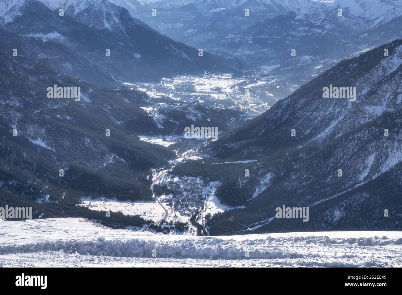 Splendida valle innevata, splendidamente annidata tra le aspre e maestose montagne, mostra l'incredibile bellezza e il fascino della landsca invernale Foto Stock