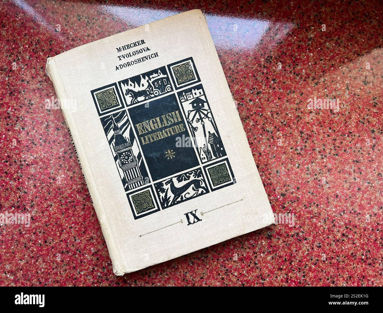 Kiev, Ucraina - 07 gennaio 2025: Un libro di colore beige con copertina illustrata, su sfondo rosso testurizzato. Il coperchio raffigura una b ornata Foto Stock