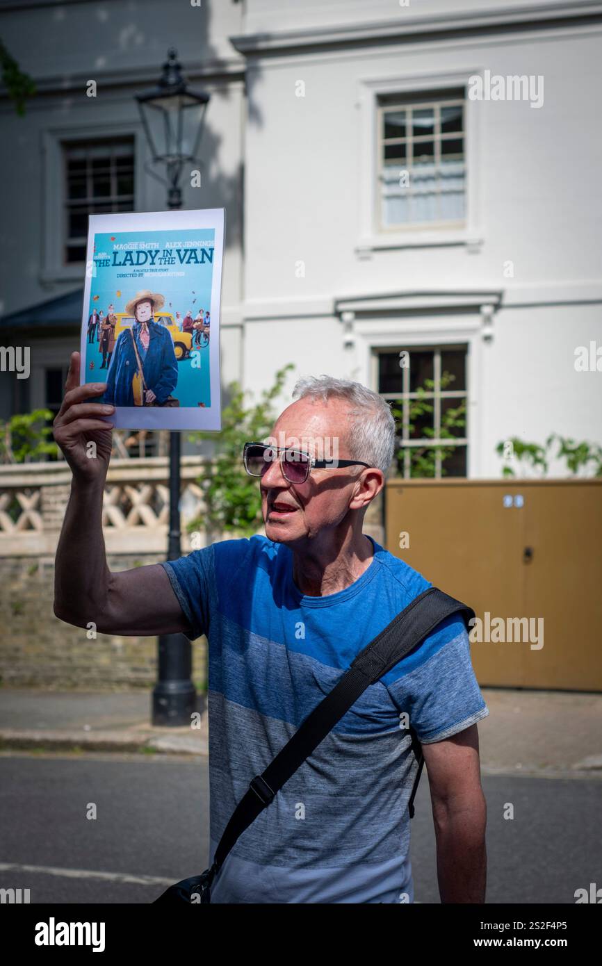 Una guida turistica da Meetup che parla con il gruppo in una strada trafficata di Camden. Foto Stock