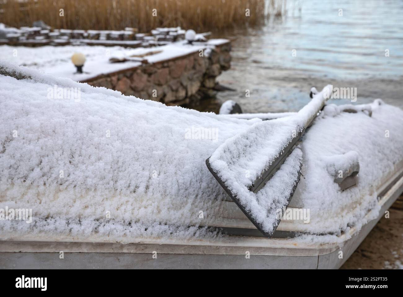 Imbarcazione gonfiabile coperta di neve sulla riva in inverno Foto Stock