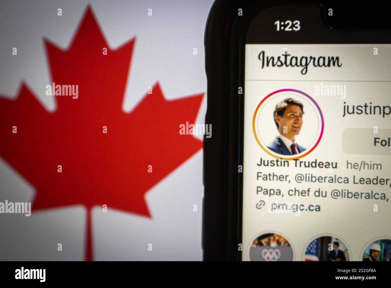 Smartphone che mostra il profilo di Justin Trudeau su Instagram, con la bandiera canadese sullo sfondo che simboleggia un punto di svolta nella leadership canadese Foto Stock