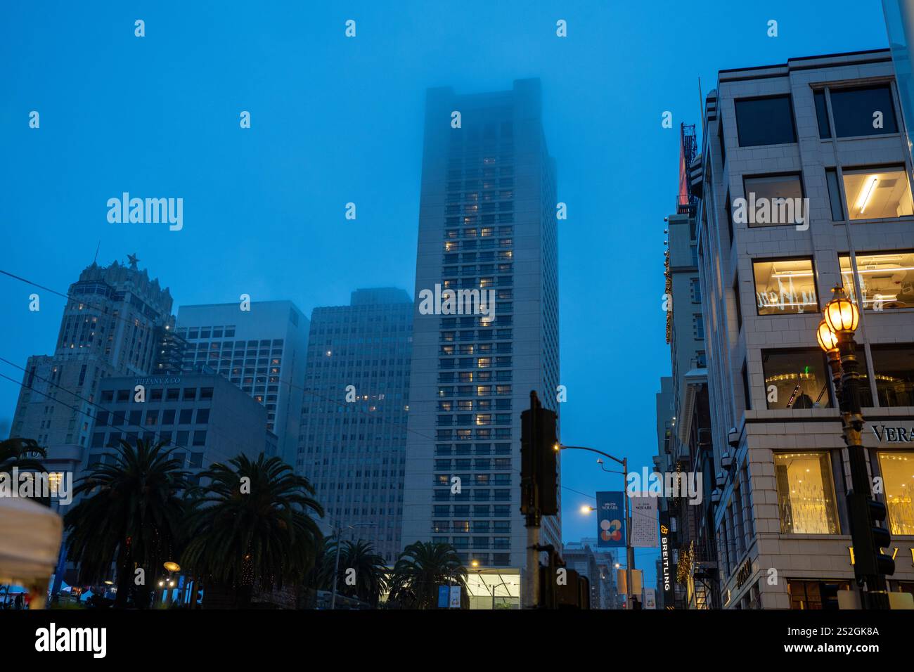 San Francisco California - 21 dicembre 2024: Edifici nel centro di San Francisco vicino a Union Square a Dusk con nebbia che copre alcune delle torri Foto Stock
