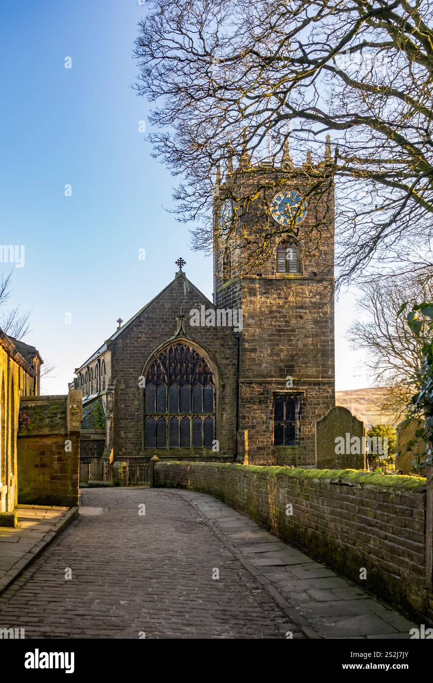 St Michael All Angels Church a Haworth, West Yorkshire, vista da Church Street con la Old School a sinistra. REGNO UNITO Foto Stock