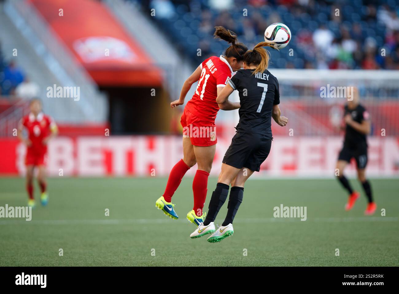 WINNIPEG, CANADA - 15 GIUGNO: Wang Lisi della Cina (21) e Ali Riley della nuova Zelanda (7) si sfidano per un colpo di testa durante una partita del gruppo A della Coppa del mondo femminile FIFA il 15 giugno 2015 al Winnipeg Stadium di Winnipeg, Canada. Solo per uso editoriale. Uso commerciale vietato. (Fotografia di Jonathan Paul Larsen / Diadem Images) Foto Stock