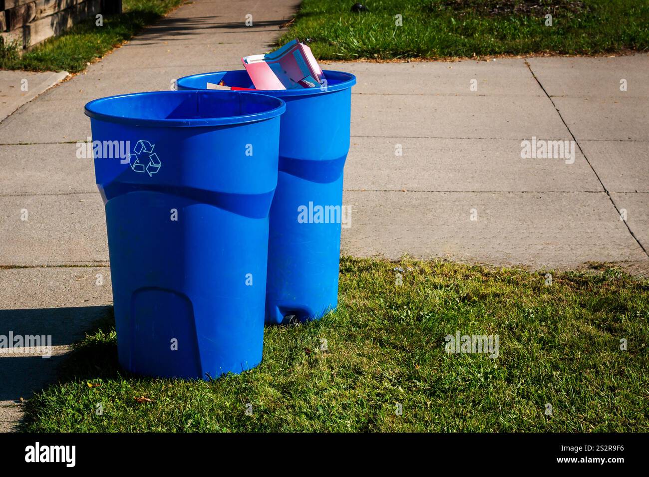 Due bidoni di riciclaggio blu su un marciapiede a Hamilton, Ontario, Canada Foto Stock