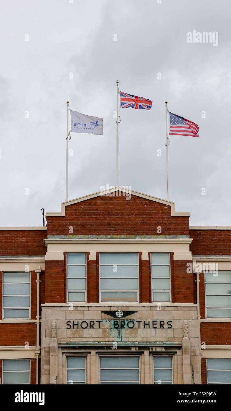 La bandiera e le bandiere della Spirit Aerosystems sulla facciata anteriore dell'edificio industriale art deco Short Brothers Belfast. Foto Stock