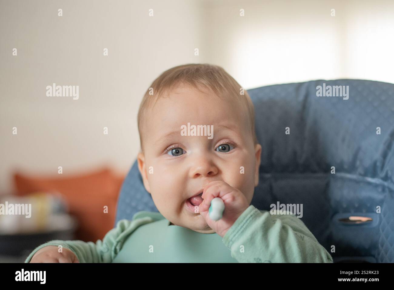 bimbo di 6 mesi che inizia a nutrire cibi solidi usando il cucchiaio da addestramento Foto Stock
