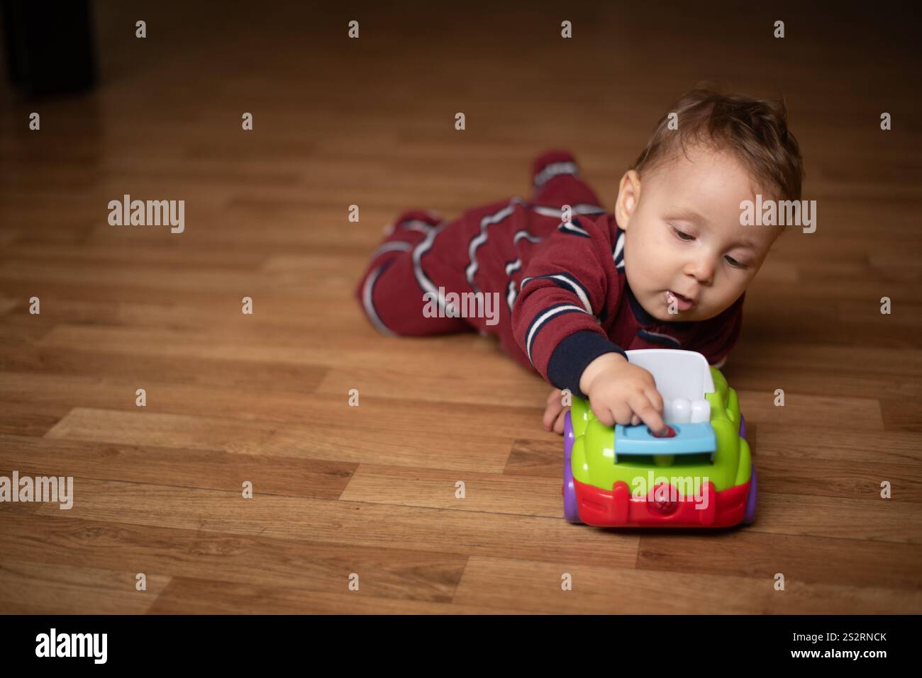 Il bambino gioca con l'auto giocattolo Foto Stock