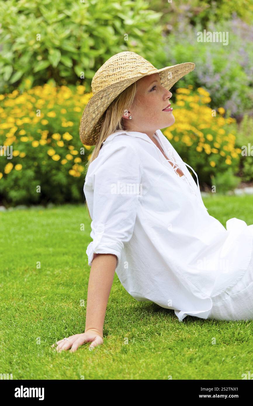 Una giovane donna si siede nel prato per rilassarsi. Pausa pranzo nel parco. Austria Foto Stock