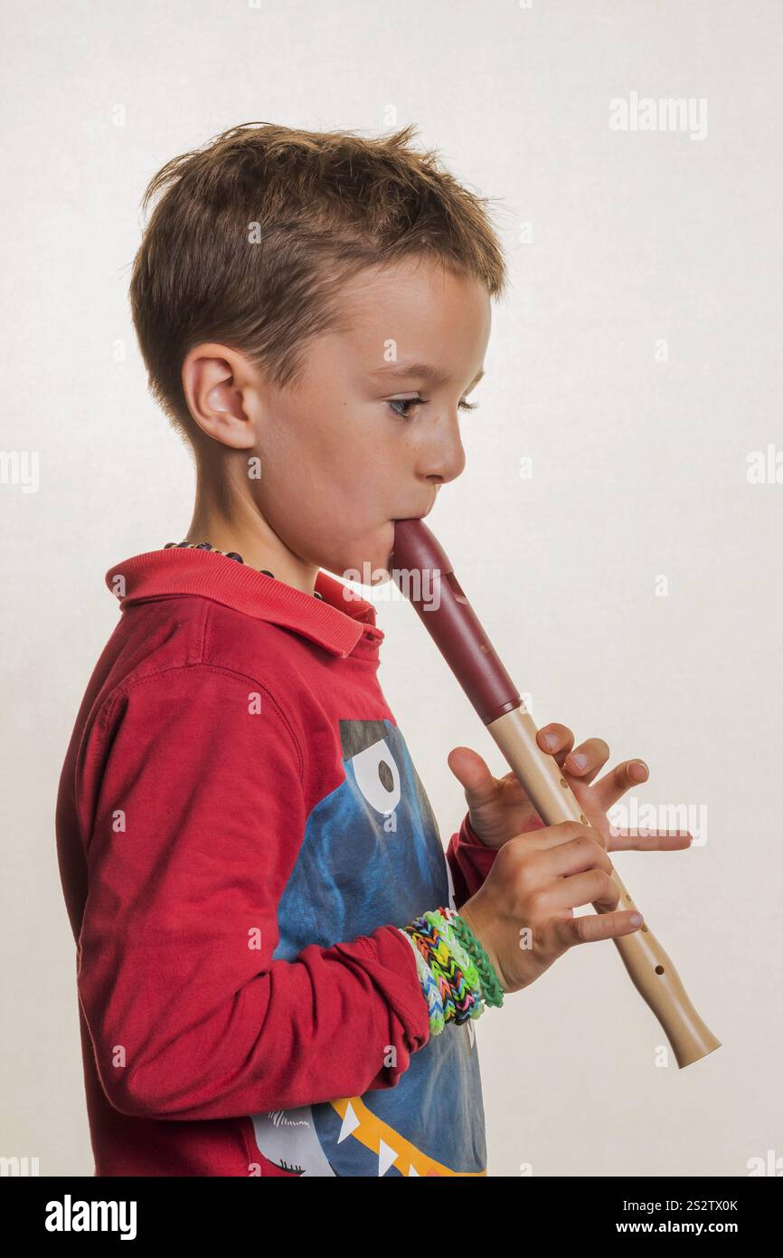 Un bambino suona un flauto sul legno. Educazione musicale e scuola di musica. Austria Foto Stock