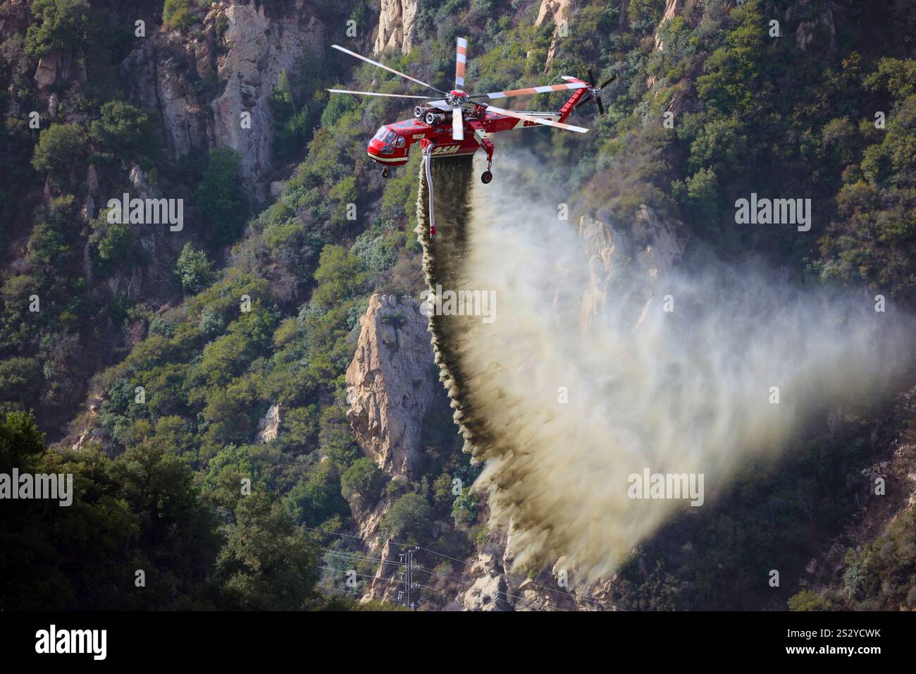 LOS ANGELES COUNTY, CALIFORNIA, USA - dicembre 2024 - Un elicottero antincendio specializzato getta l'acqua su un canyon nella contea di Los Angeles, California, Foto Stock