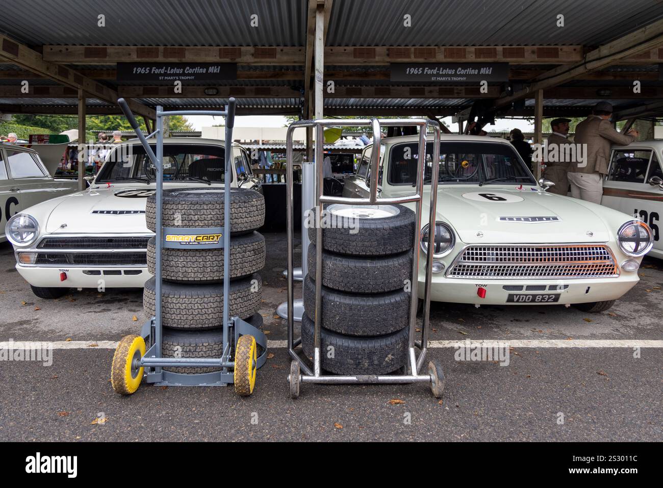 I partecipanti al St Mary's Trophy 1965 Ford-Lotus Cortinas nel garage del paddock al Goodwood Revival 2024, storico evento motoristico, Sussex, Regno Unito. Foto Stock