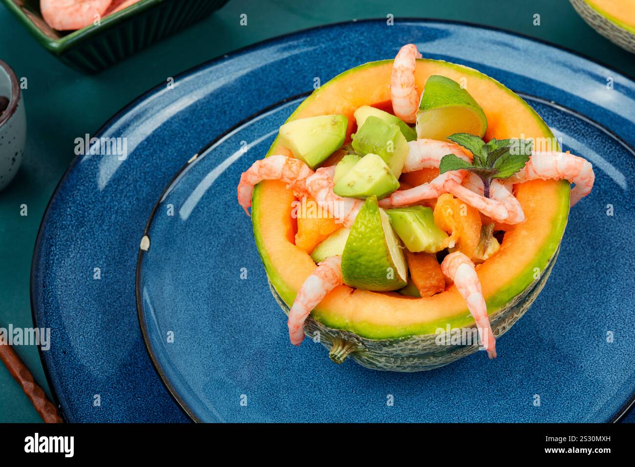 Insalata, Macedonia di frutta di gamberetti, melone e avocado in mezzo melone. Foto Stock