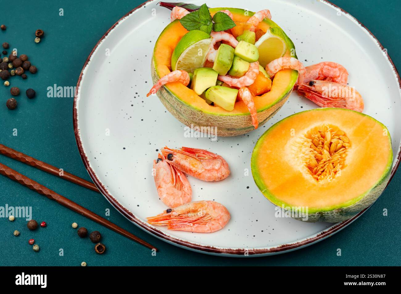 Insalata, Macedonia di frutta di gamberetti, melone e avocado in mezzo melone. Foto Stock