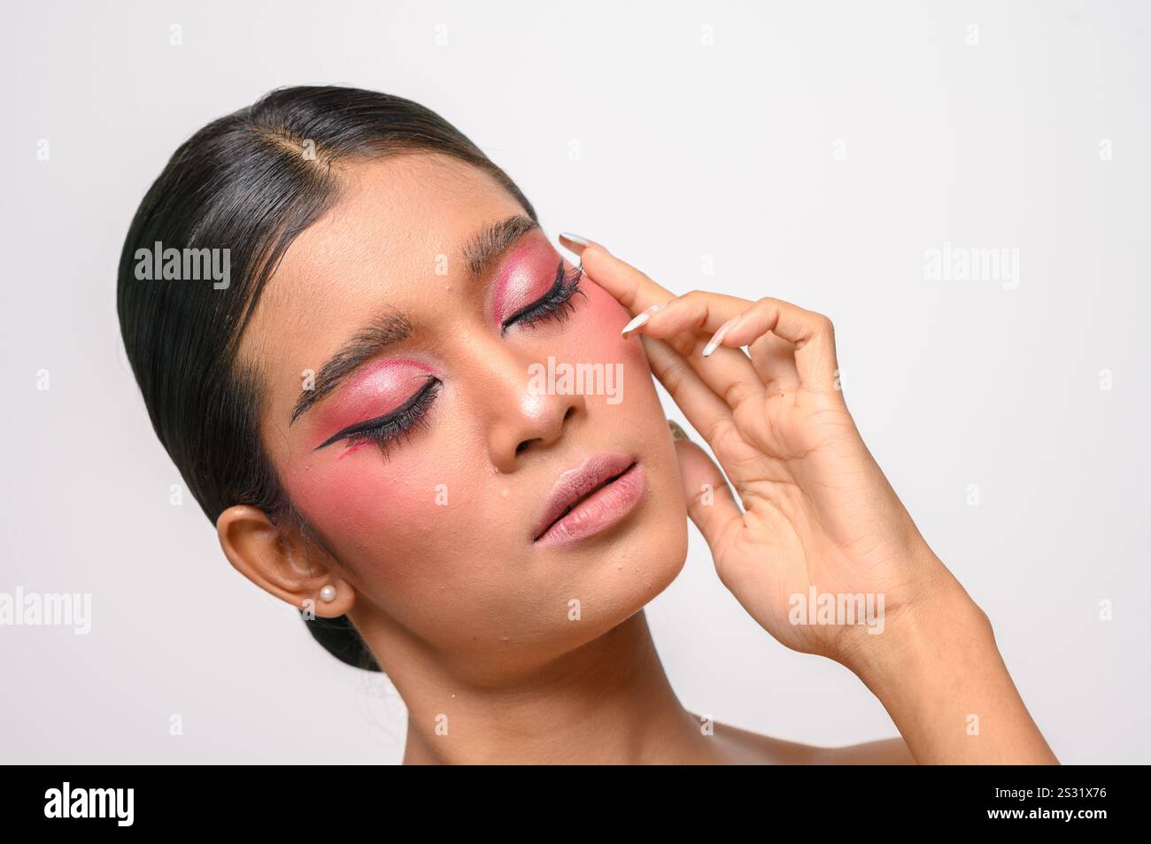La donna si è messa il trucco rosa e ha messo la mano sul viso. Isolato su sfondo bianco Foto Stock