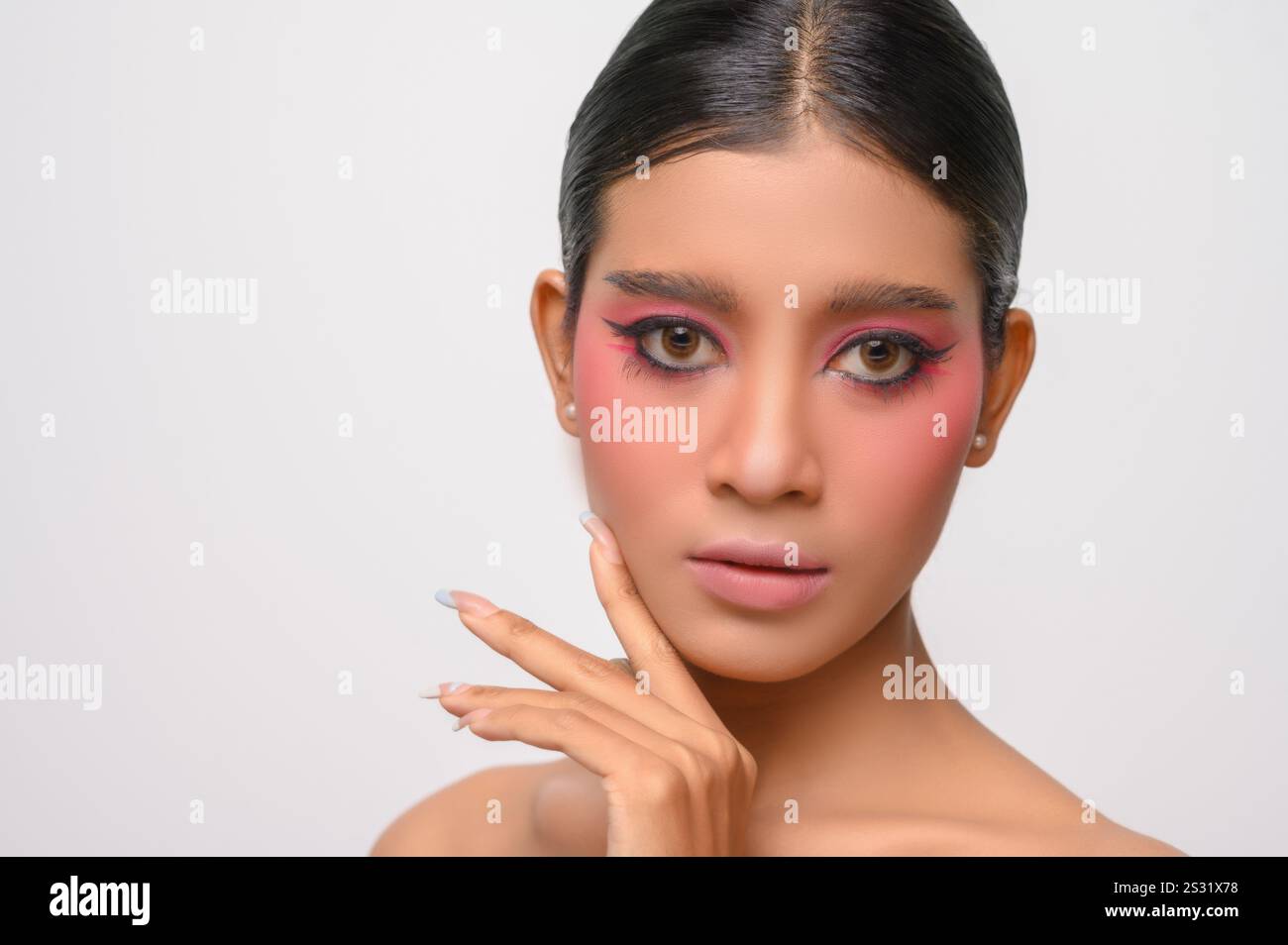 La donna si è messa il trucco rosa e ha messo la mano sul viso. Isolato su sfondo bianco Foto Stock