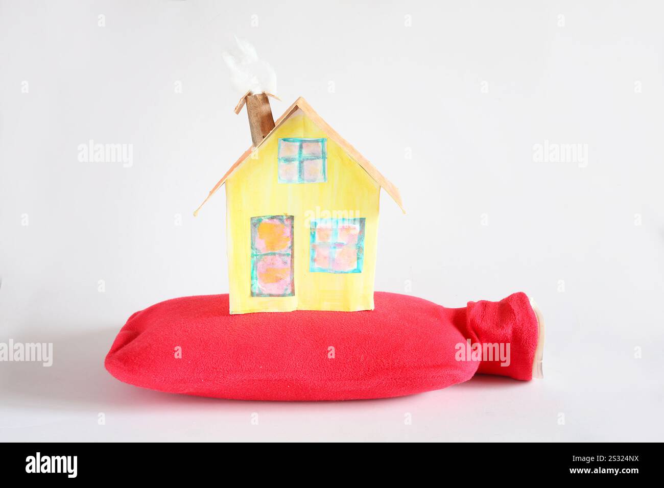 Modello di casa con bottiglia d'acqua calda. Stagione invernale, aumento dei costi di riscaldamento e prezzi dell'energia cocnept. Spazio libero per le copie Foto Stock