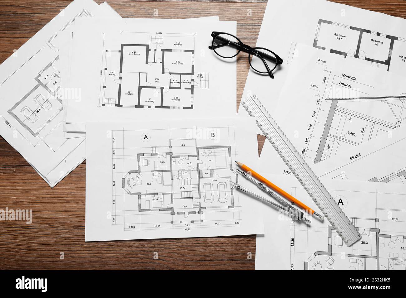 Diversi disegni architettonici, matita, righello, vetri e divisore su tavolo in legno, piatto Foto Stock