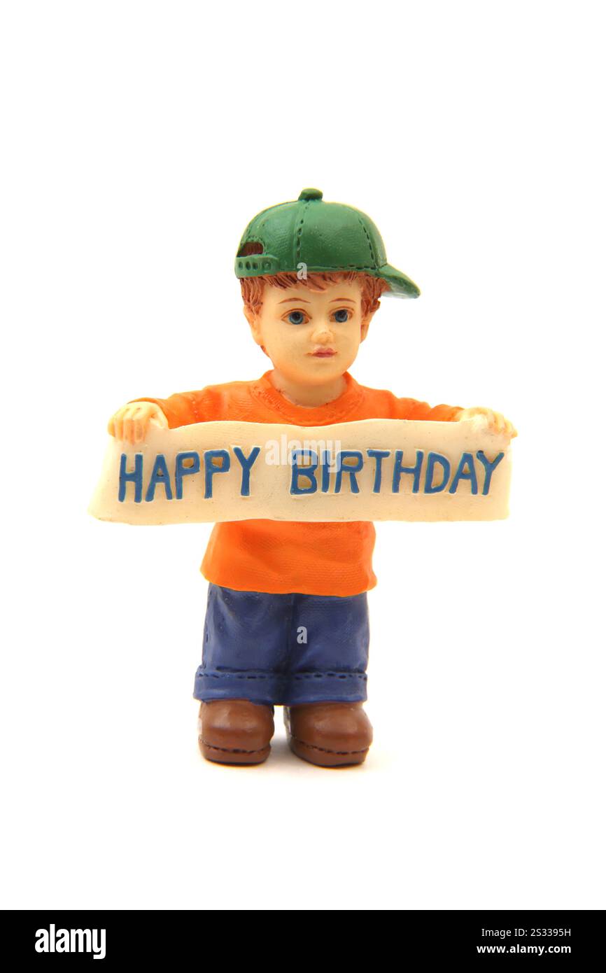 Candela in cera a forma di ragazzo che tiene in mano la bandiera "buon compleanno" Foto Stock