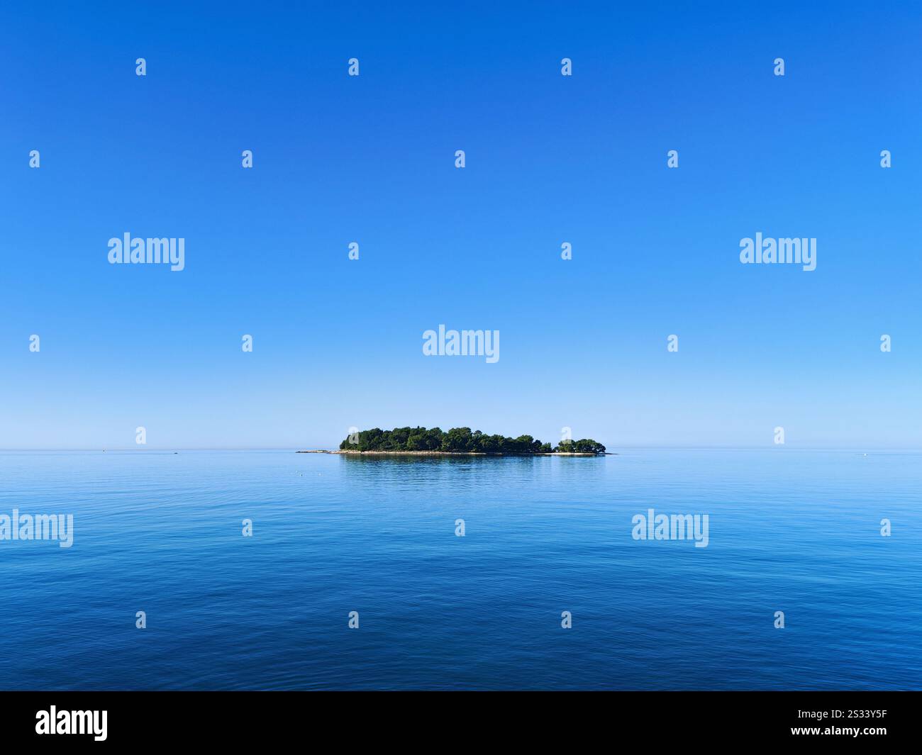 Isola isolata su un mare calmo Foto Stock