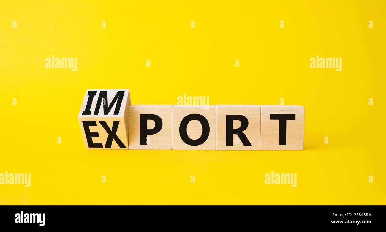 Simbolo di importazione ed esportazione. Cubi di legno torniti con parole Esporta e Importa. Bellissimo sfondo giallo. Concetto di business. Copia spazio. Foto Stock