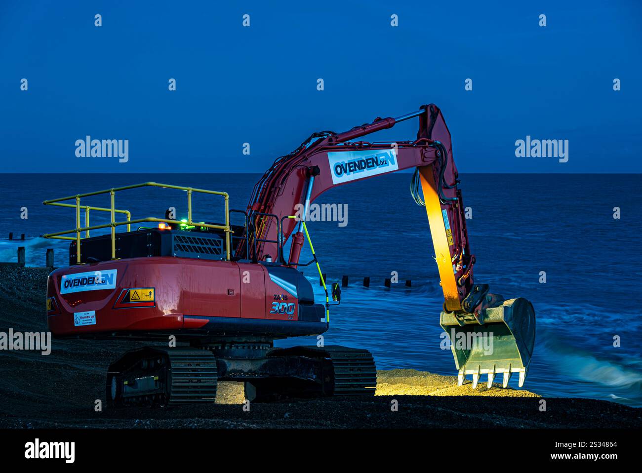 Appaltatori dell'Agenzia ambientale al lavoro, in tarda giornata invernale, per il sistema di gestione costiera da Pevensey Bay a Eastbourne Foto Stock