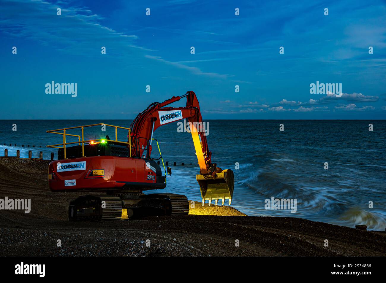 Appaltatori dell'Agenzia ambientale al lavoro, in tarda giornata invernale, per il sistema di gestione costiera da Pevensey Bay a Eastbourne Foto Stock