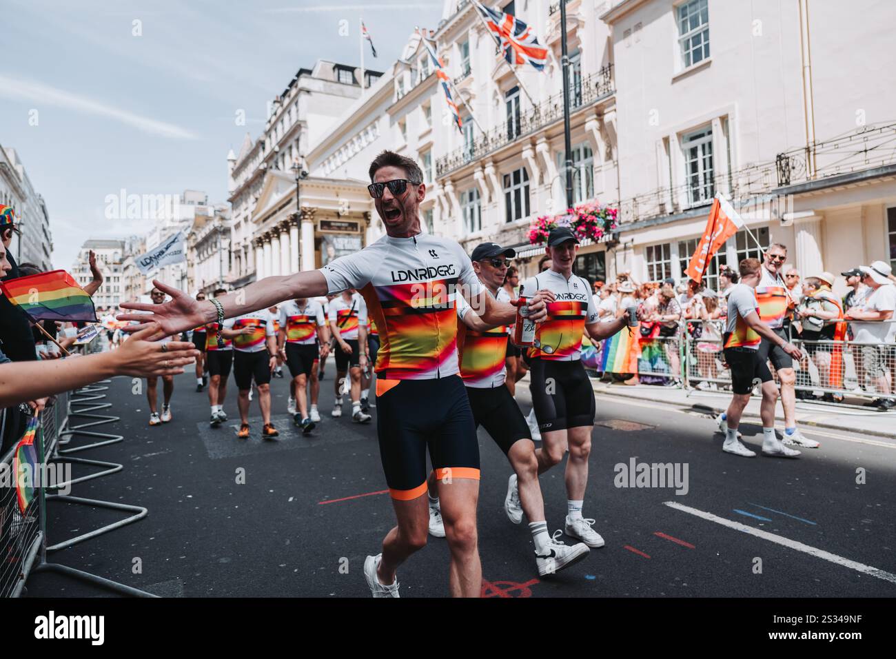 Corridori che festeggiano in una vivace Parata del Pride con bandiere colorate e feste a Londra. 2024 Foto Stock