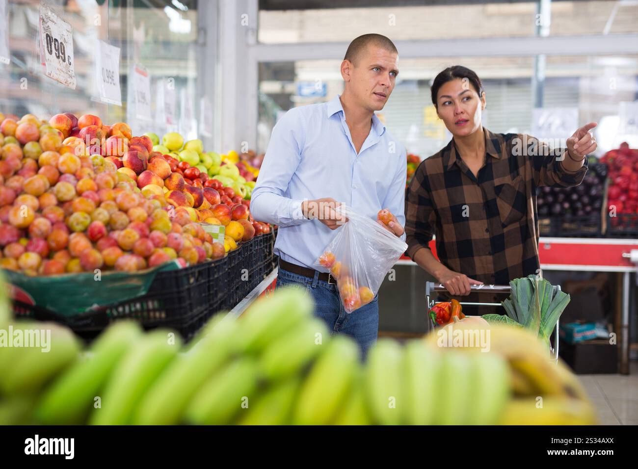 Coppia di famiglia in cerca di frutta e verdura in fruttivendolo Foto Stock