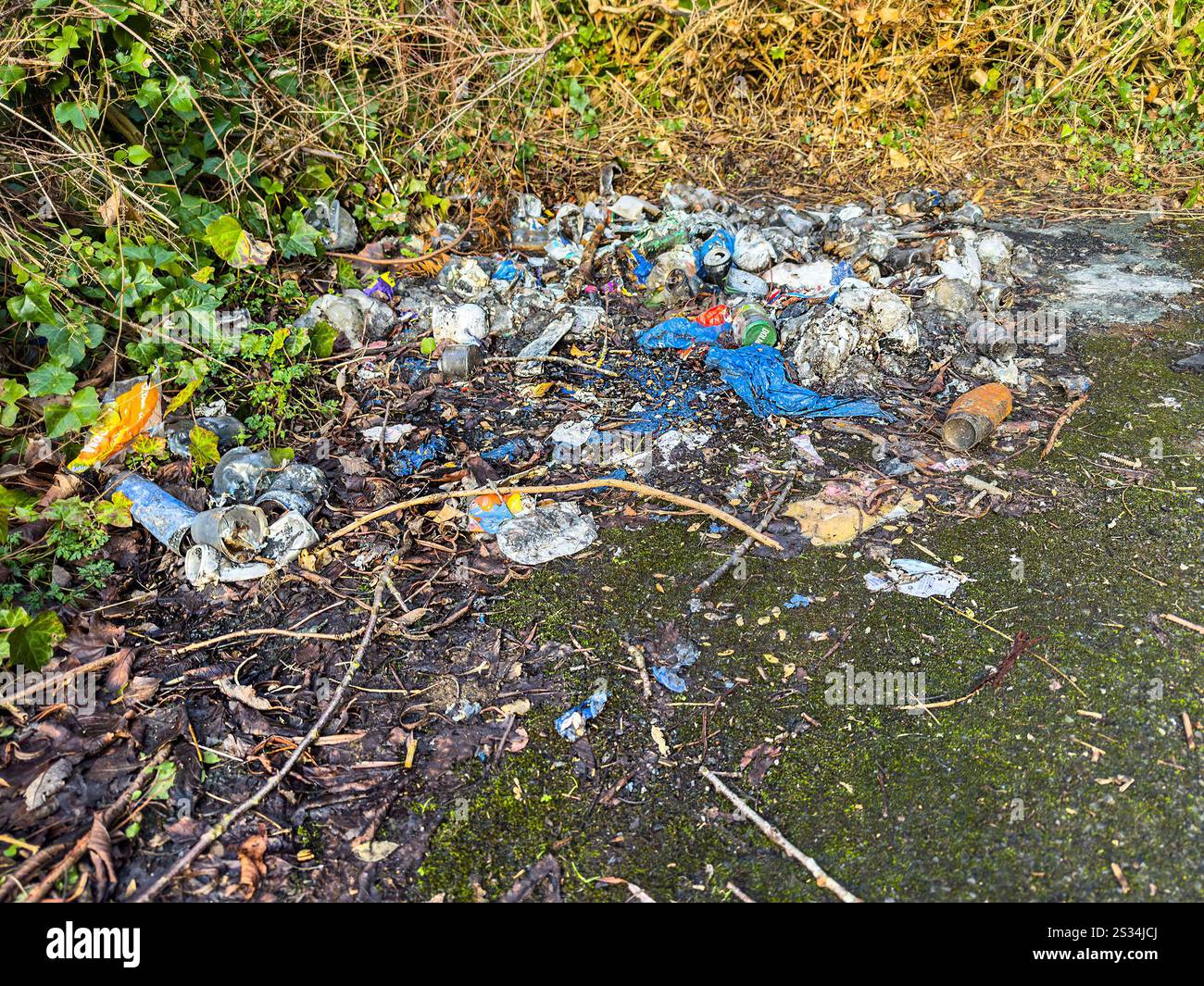 Un mucchio di rifiuti bruciati e incombusti con detriti di plastica e cenere sul lato di una strada in un ambiente naturale - volare ribaltando newcastle upon tyne uk - Immagine stock catturata con smartphone