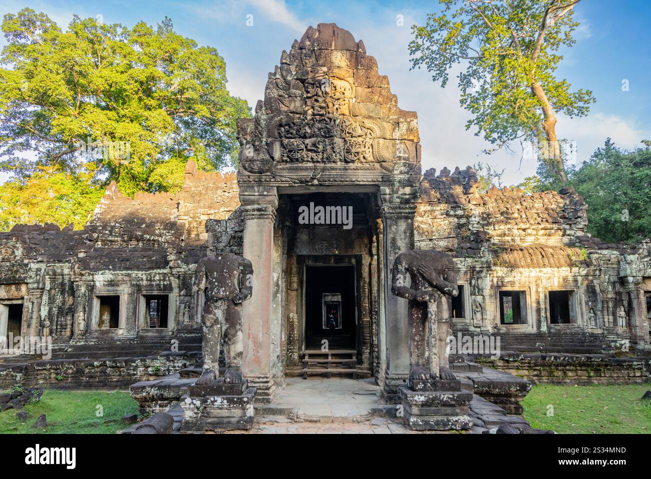 Custodito da statue guerriere, l'antico tempio in rovina hindu Preah Khan khmer nascosto nelle giungle, il parco archeologico di Angkor, Siem Reap, Cambogia Foto Stock