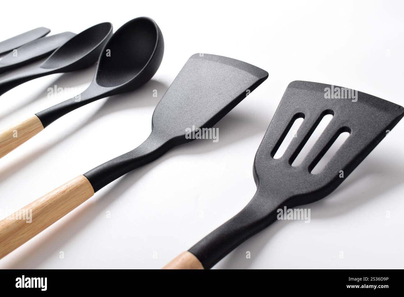 Set di utensili da cucina in silicone con manico in legno isolato su sfondo bianco. Set di utensili da cucina Foto Stock