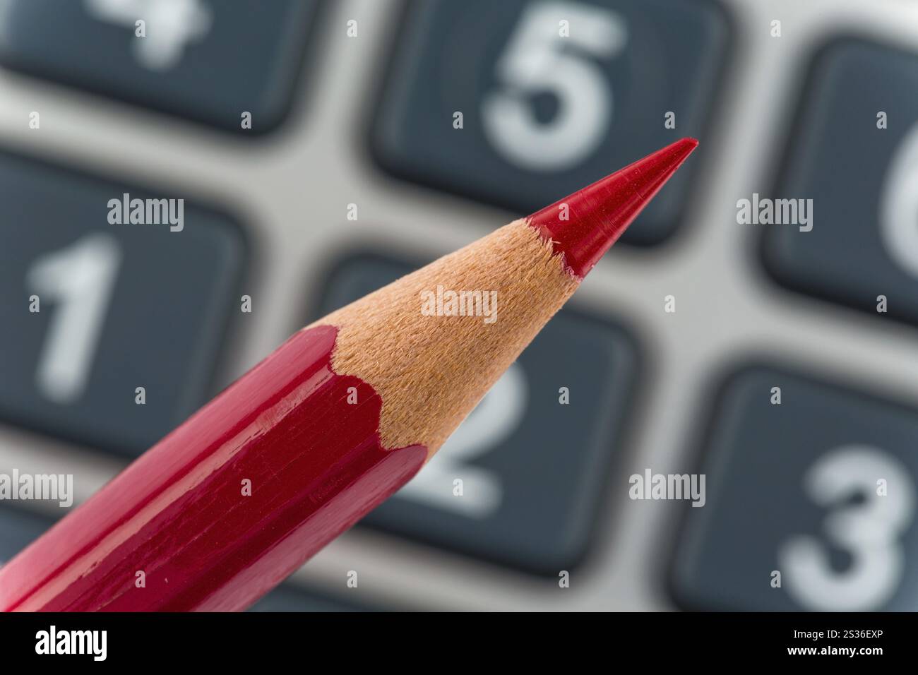 Una penna rossa giace su una calcolatrice tascabile. Risparmio sui costi, sulle spese e sul bilancio a causa della scarsa situazione economica Austria Foto Stock