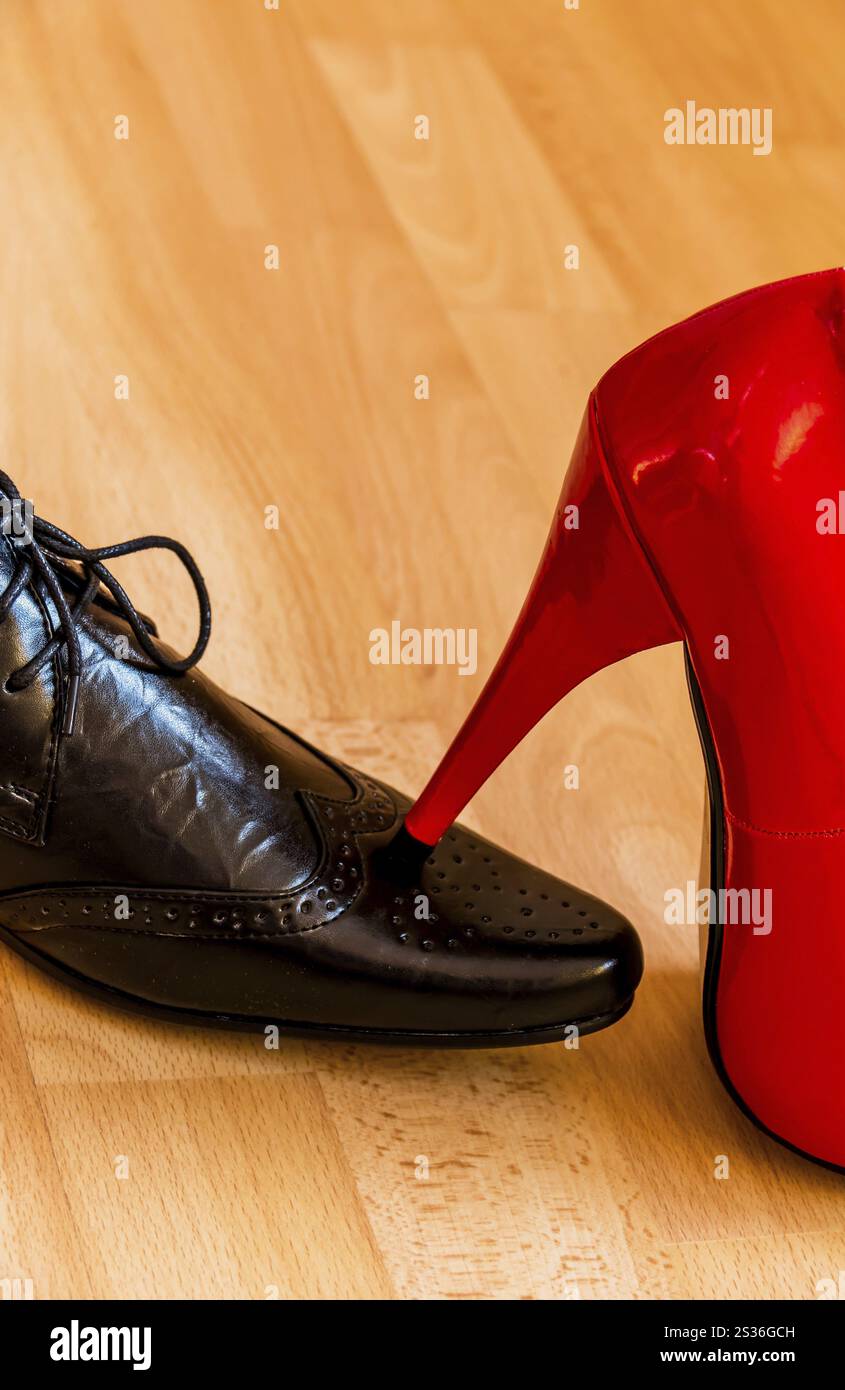 Una donna calpesta un uomo con i tacchi alti. Foto simbolica per eguaglianza e bullismo. Austria Foto Stock