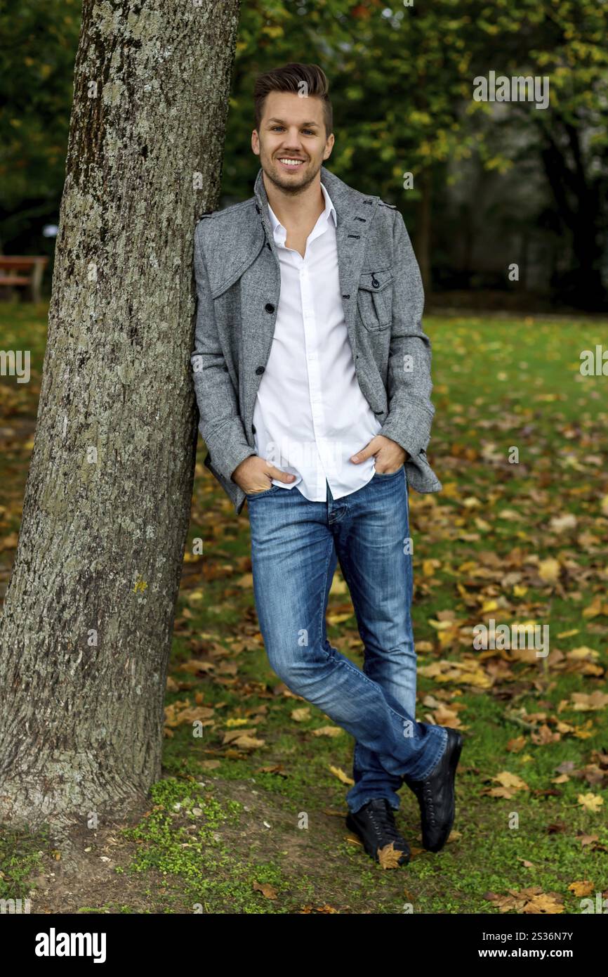 Giovane uomo appoggiato contro un albero Austria Foto Stock