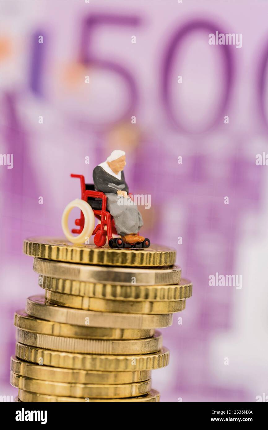 Donna in sedia a rotelle su mucchio di soldi, foto simbolica per la disabilità, indennità di assistenza e costi di assistenza sanitaria Foto Stock
